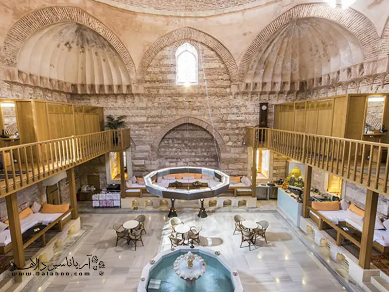 معماری گرمخانه خیره‌کننده است: سقف گنبدی شکل، حوض و سکوهایی با سنگ مرمر.